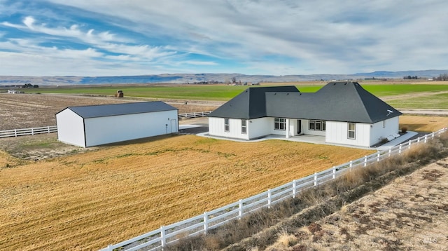 view of front of property featuring an outbuilding, a rural view, an outdoor structure, and fence