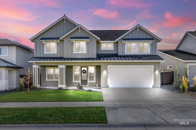 view of front of property featuring a garage and a lawn