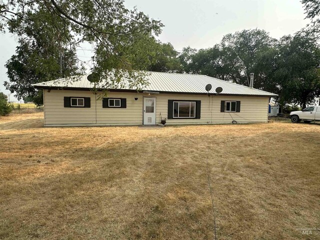 back of property featuring a lawn