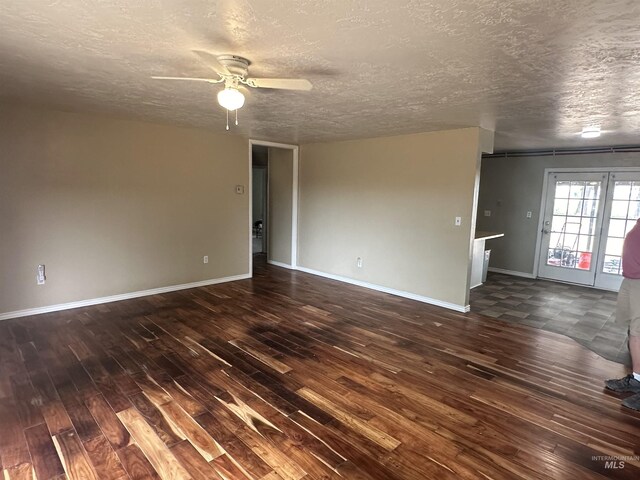 spare room featuring a textured ceiling, ceiling fan, and dark tile patterned flooring