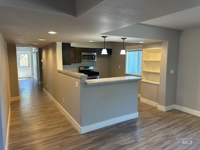10331 W Utahna, Boise, ID 83714 - kitchen featuring stainless steel appliances, baseboards, light countertops, wood finished floors, and a textured ceiling