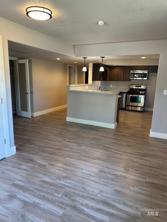 10331 W Utahna, Boise, ID 83714 - kitchen featuring stainless steel appliances, baseboards, dark wood-style floors, a textured ceiling, and pendant lighting