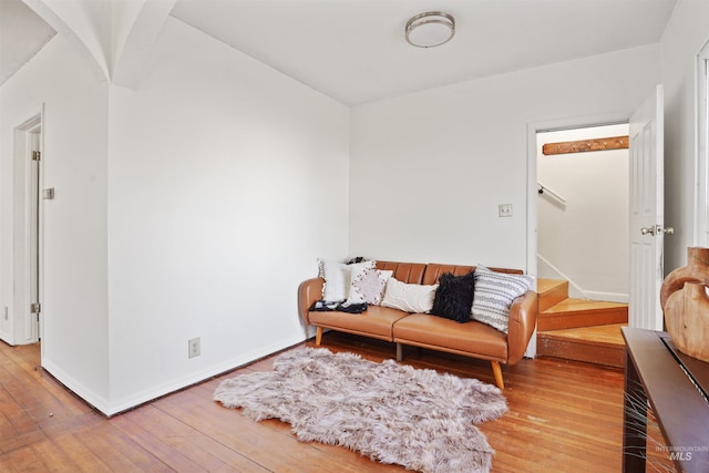 living area with baseboards, stairway, and wood finished floors