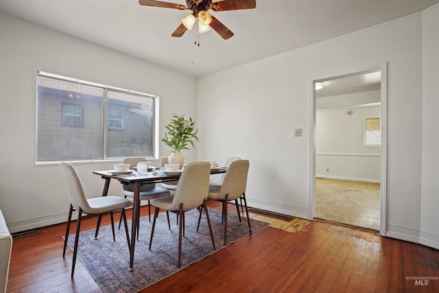 dining area featuring ceiling fan, wood finished floors, visible vents, and baseboards