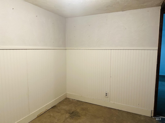 2901 Almo Ave, Burley, ID 83318 - unfurnished room featuring unfinished concrete flooring, a wainscoted wall, and wood walls
