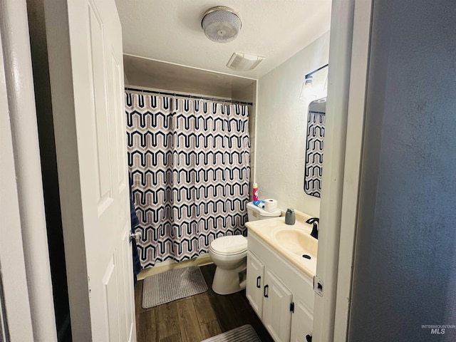 2901 Almo Ave, Burley, ID 83318 - bathroom featuring vanity, wood finished floors, toilet, curtained shower, and a textured wall
