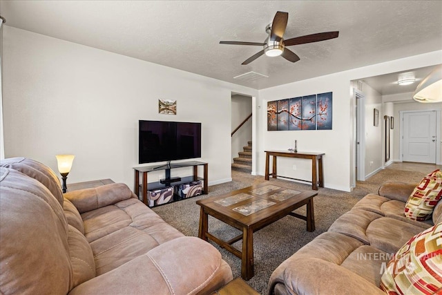 living room with carpet flooring, a textured ceiling, stairs, and baseboards