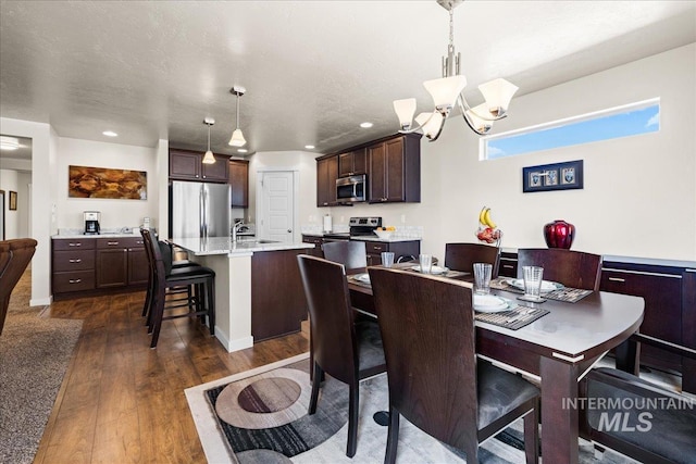 dining room featuring dark wood-style floors, a notable chandelier, recessed lighting, and a textured ceiling