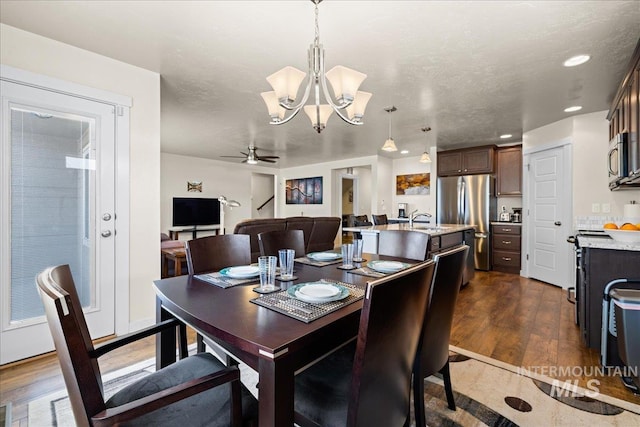 dining area featuring ceiling fan with notable chandelier, recessed lighting, dark wood-style floors, and a textured ceiling