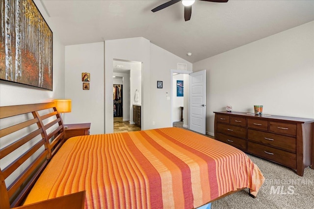 bedroom featuring light colored carpet, ensuite bath, a ceiling fan, and vaulted ceiling