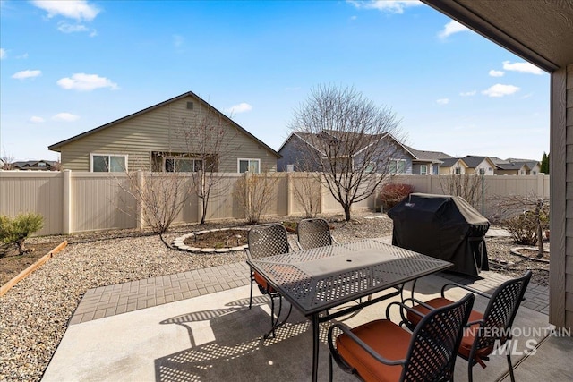 view of patio featuring grilling area, outdoor dining area, and a fenced backyard