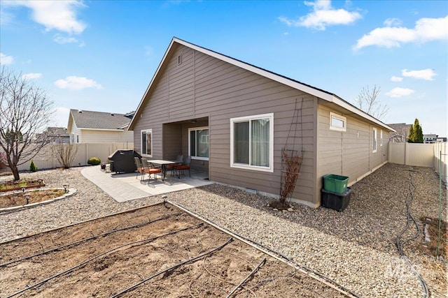 rear view of house featuring crawl space, a fenced backyard, and a patio area