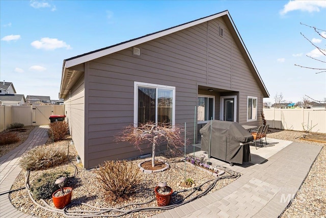 back of property with a fenced backyard and a patio area