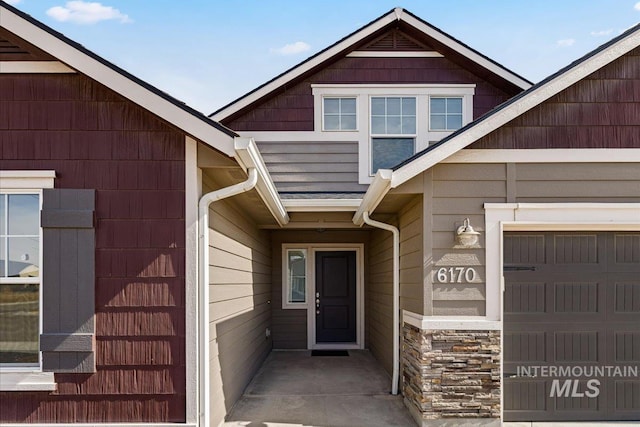 entrance to property with a garage and stone siding