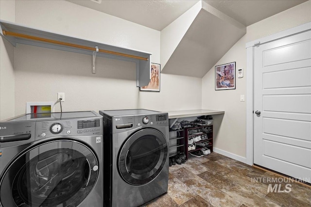 clothes washing area with baseboards, independent washer and dryer, laundry area, and stone finish floor