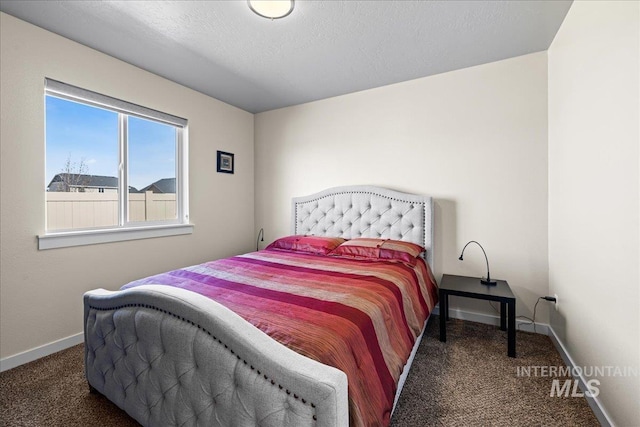 carpeted bedroom with baseboards and a textured ceiling