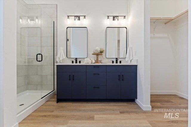 2031 S Makar Ln, Boise, ID 83706 - full bathroom with a shower stall, double vanity, a walk in closet, wood finished floors, and baseboards