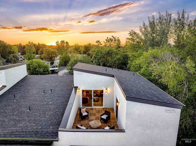 2031 S Makar Ln, Boise, ID 83706 - back of property at dusk featuring a shingled roof and stucco siding