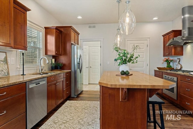 kitchen featuring visible vents, butcher block countertops, a sink, stainless steel appliances, and exhaust hood