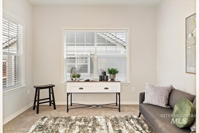 living area with light colored carpet and baseboards