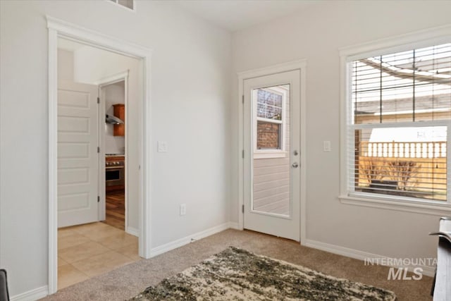 entryway featuring baseboards and light colored carpet