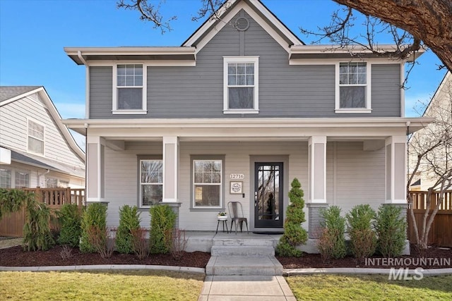 view of front of house featuring a porch and fence