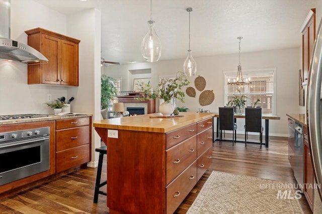 kitchen featuring stainless steel appliances, dark wood-style flooring, wall chimney exhaust hood, and wood counters