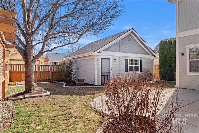 view of front of home featuring a patio area, an outdoor structure, a front lawn, and fence