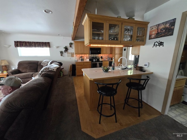 1230 Ellis Ave, Orofino, ID 83544 - kitchen featuring range with electric cooktop, black microwave, a sink, open floor plan, and a peninsula