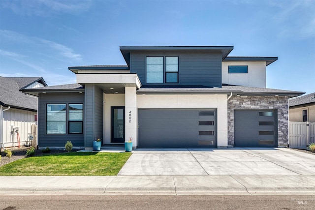 prairie-style house with fence, driveway, a front yard, and a garage