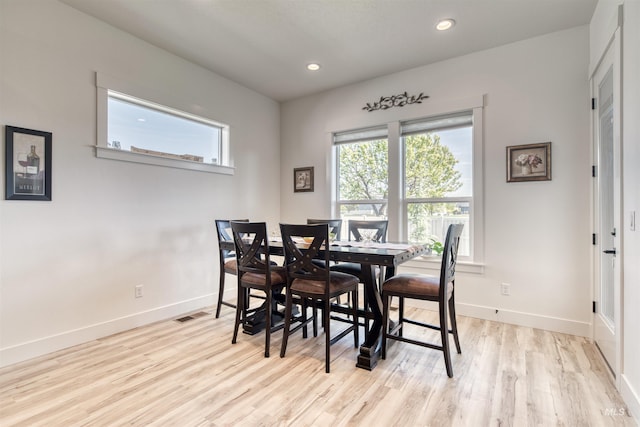 dining space featuring light wood-style floors, baseboards, and plenty of natural light