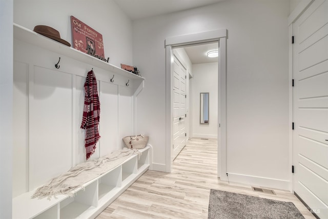 mudroom with baseboards, visible vents, and light wood-style floors
