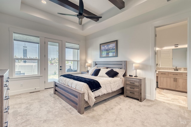 bedroom featuring access to exterior, light colored carpet, baseboards, ensuite bathroom, and a tray ceiling