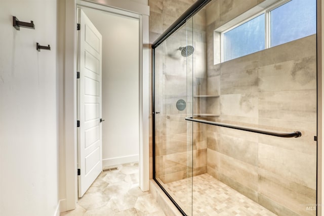 bathroom featuring baseboards and a shower stall