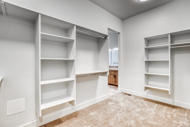 walk in closet with visible vents and light carpet