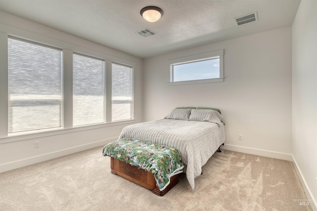 carpeted bedroom with visible vents and baseboards