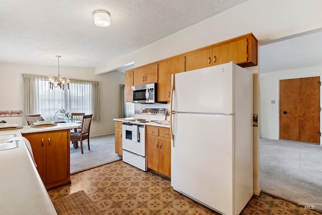 kitchen with white appliances, vaulted ceiling, hanging light fixtures, light countertops, and brown cabinets