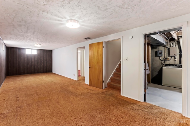 basement featuring a textured ceiling, visible vents, stairs, washer / clothes dryer, and carpet