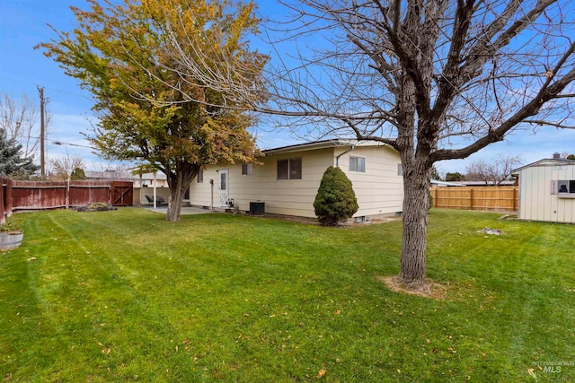 view of yard featuring a fenced backyard, a storage unit, and an outdoor structure