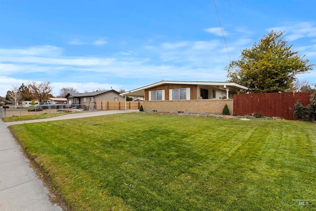 exterior space with fence private yard, brick siding, driveway, and a front yard