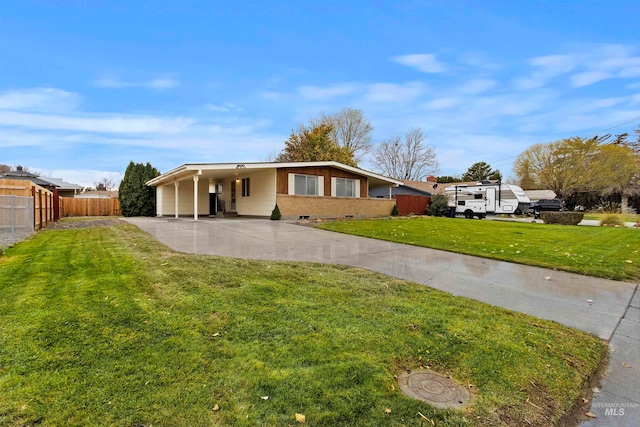 single story home featuring fence, an attached carport, concrete driveway, and a front yard