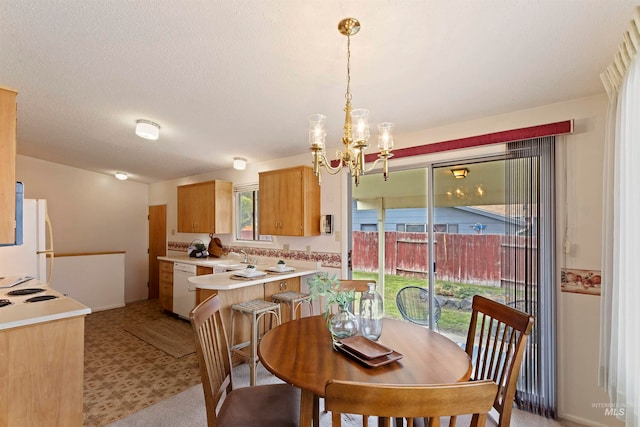 dining space with an inviting chandelier, light floors, and a textured ceiling