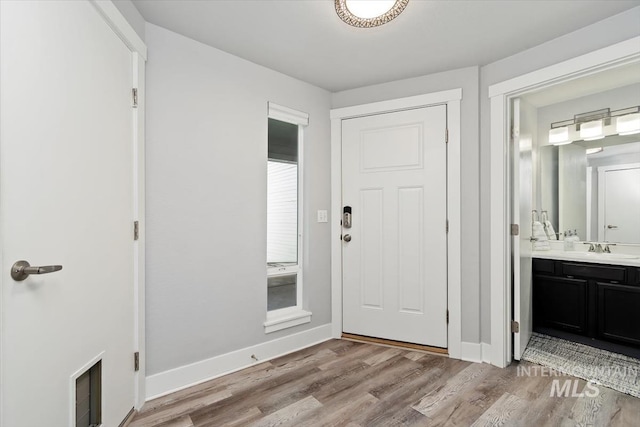 entryway with baseboards, visible vents, and light wood-style flooring
