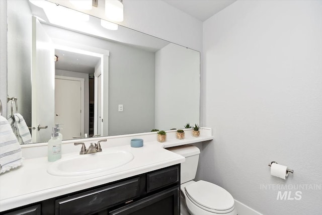 half bathroom featuring vanity and toilet
