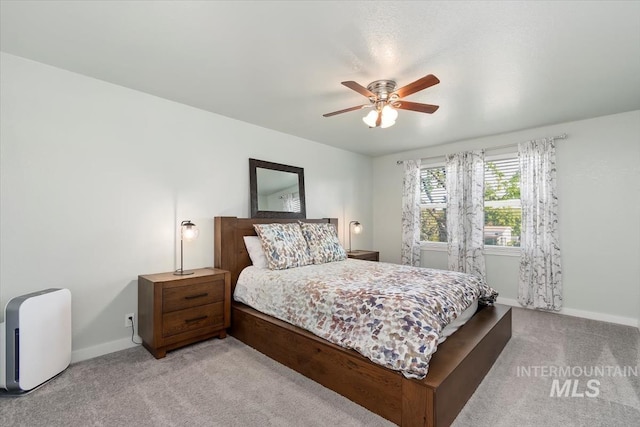 bedroom with a ceiling fan, baseboards, and light colored carpet