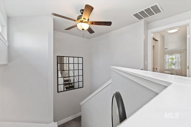 hall featuring carpet floors, baseboards, and visible vents