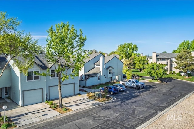 view of front of home featuring a garage, a residential view, and concrete driveway