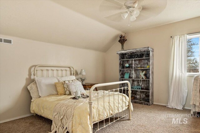 bedroom with a textured ceiling, vaulted ceiling, ceiling fan, and carpet flooring