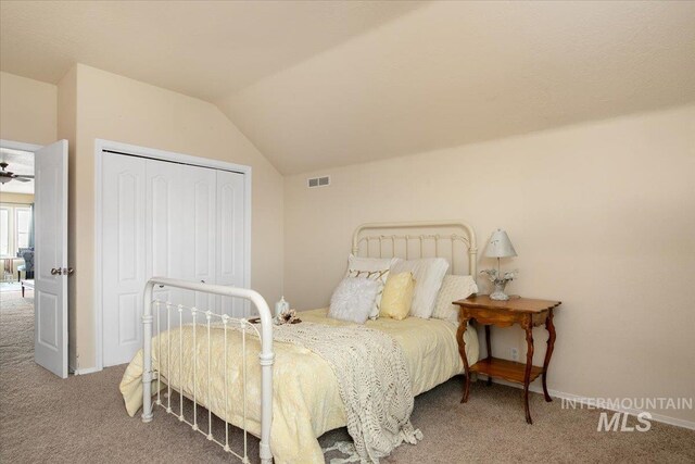 bedroom featuring vaulted ceiling, a closet, and carpet flooring