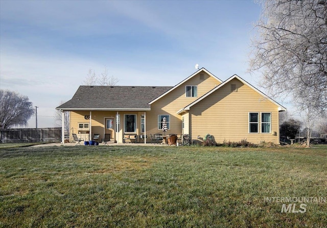 rear view of house featuring a patio and a yard